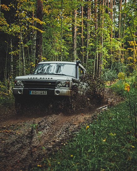 An image of a Land Rover going down a muddy road
